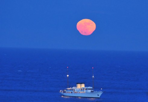 Měsíc vycházející nad Středozemní moře má neobvyklý tvar, je totiž deformován vlivem tzv. atmosférické refrakce. Zdroj: Jean-Marc Audrin.