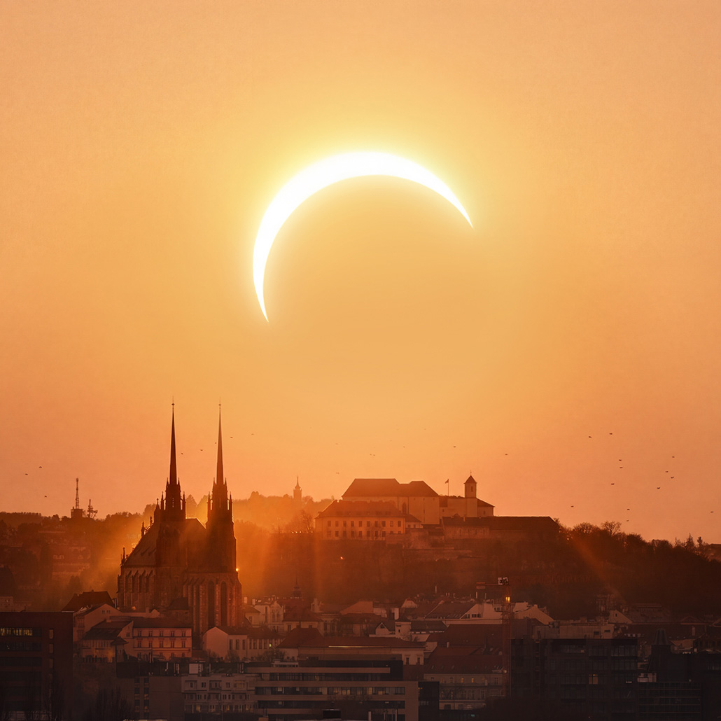 Slunce nízko nad horizontem. Zhruba v okamžiku maximální fáze zatmění při pohledu z Brna.